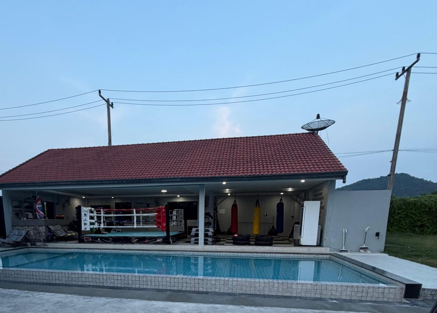 The pool in front of the open-sided gym with ring and heavy bags